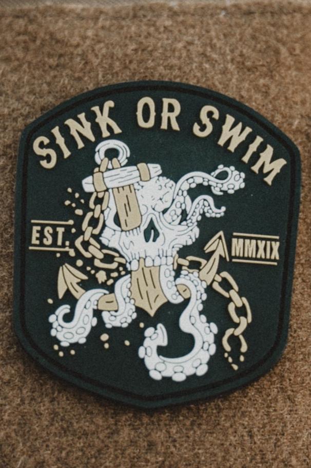The Relentless Betrayal Sink Or Swim Kraken PVC Patch features a skull with octopus tentacles and a wooden anchor, broken chains, and the text SINK OR SWIM and EST. MMXIX—symbolizing resilience in adversity.